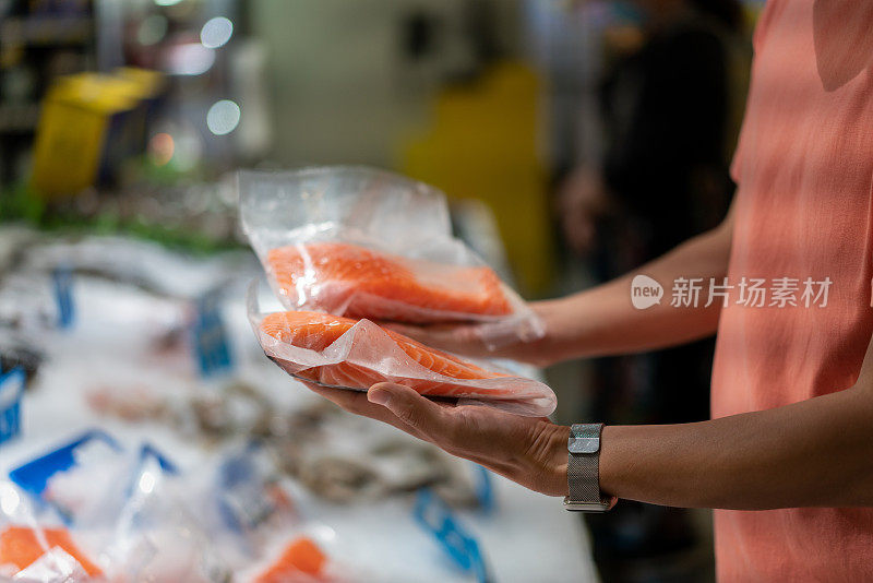 一名男子在超市挑选鲑鱼