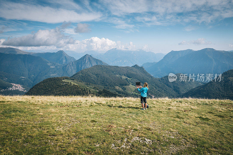 女徒步旅行者在山脊上用笔记本电脑工作