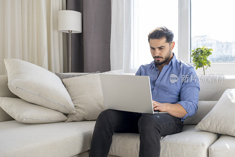 英俊的年轻人正在用笔记本电脑聊天