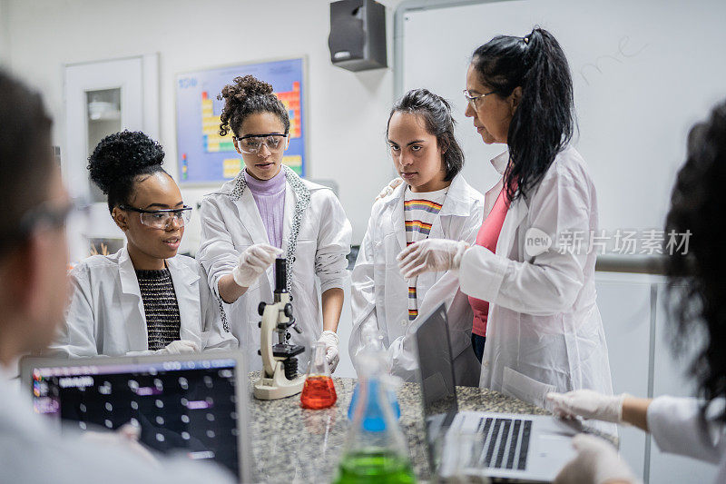 化学老师在学校的实验室里教授学生，包括有特殊需要的学生