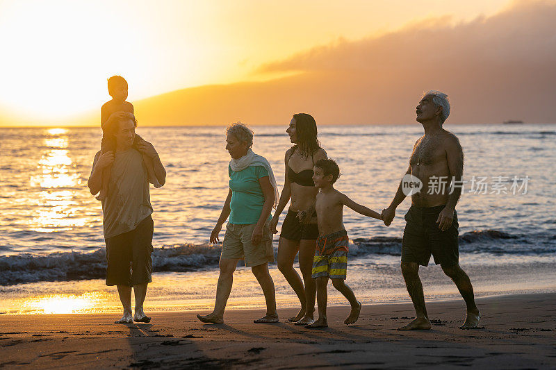 夕阳西下，几代人在海滩上散步