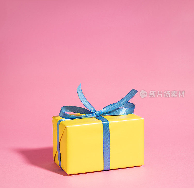 黄色礼品盒上有粉红色的蓝丝带