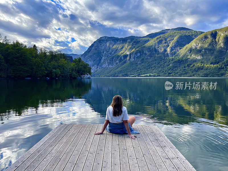 一位中年妇女在斯洛文尼亚博欣吉湖畔的码头上享受宁静的时光