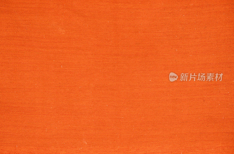 一条旧的纯色橘色编织地毯。