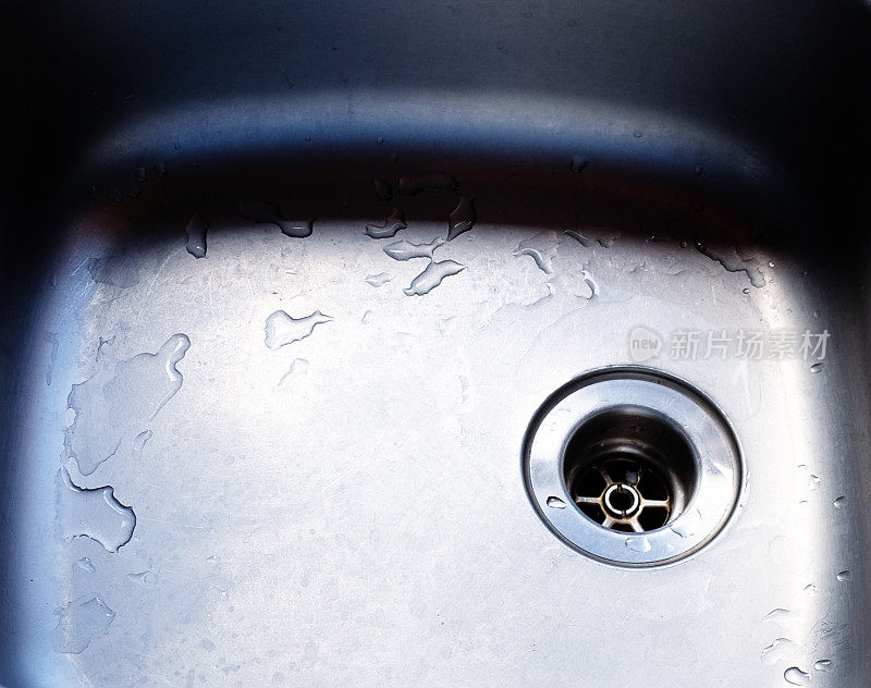 带塞孔的湿不锈钢厨房水槽特写