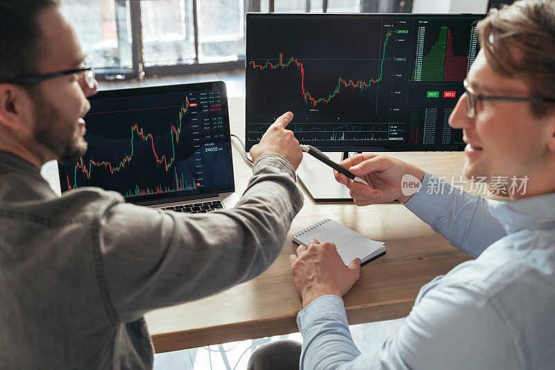 罕见的两个交易者投资者坐在桌子一起分析价格流，讨论利率