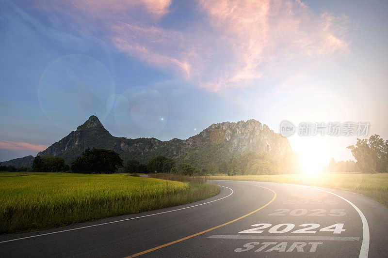 2024新年2024或2024字的概念开头写在一条路中间，一条柏油路以山为背景，夕阳为背景，概念
