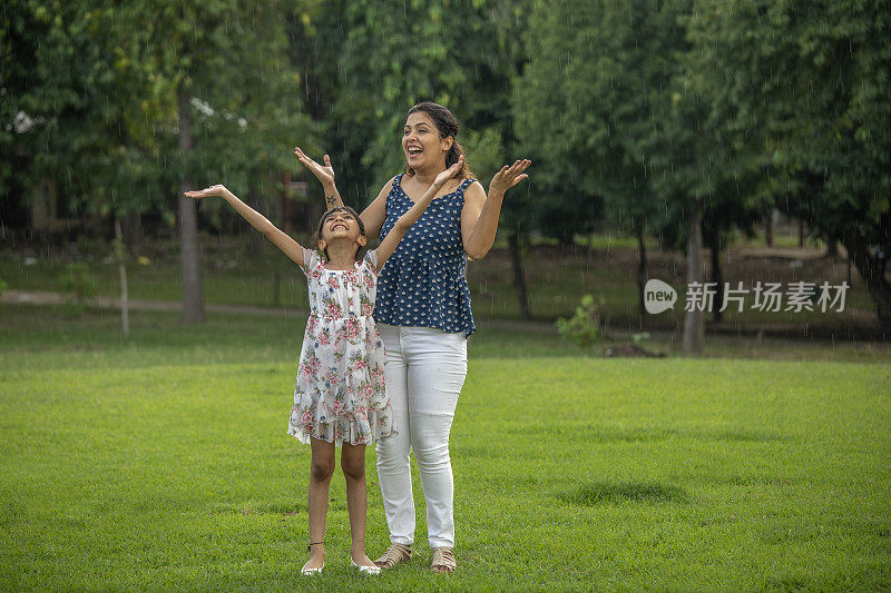 母亲和女儿在公园里享受雨水