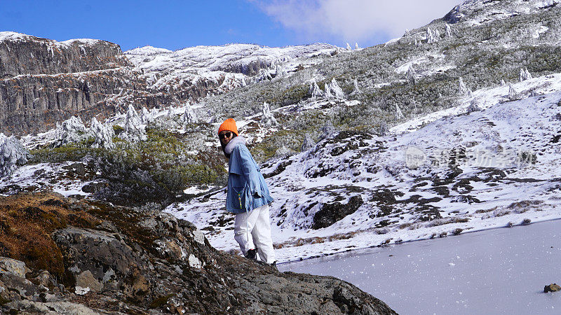 一个女人在寒冷的天气里穿行于白雪覆盖的山林之中