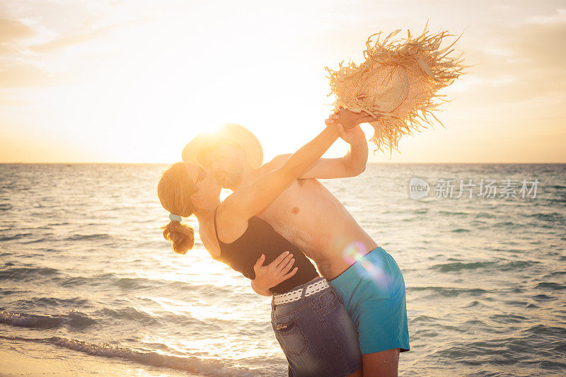 有趣的夫妇拥抱亲吻日落海滩