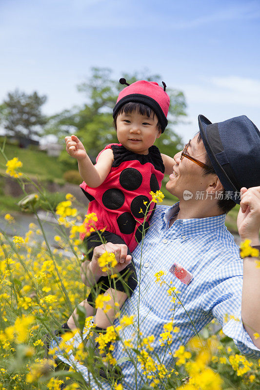 年轻的父亲和他可爱的女儿穿着瓢虫装