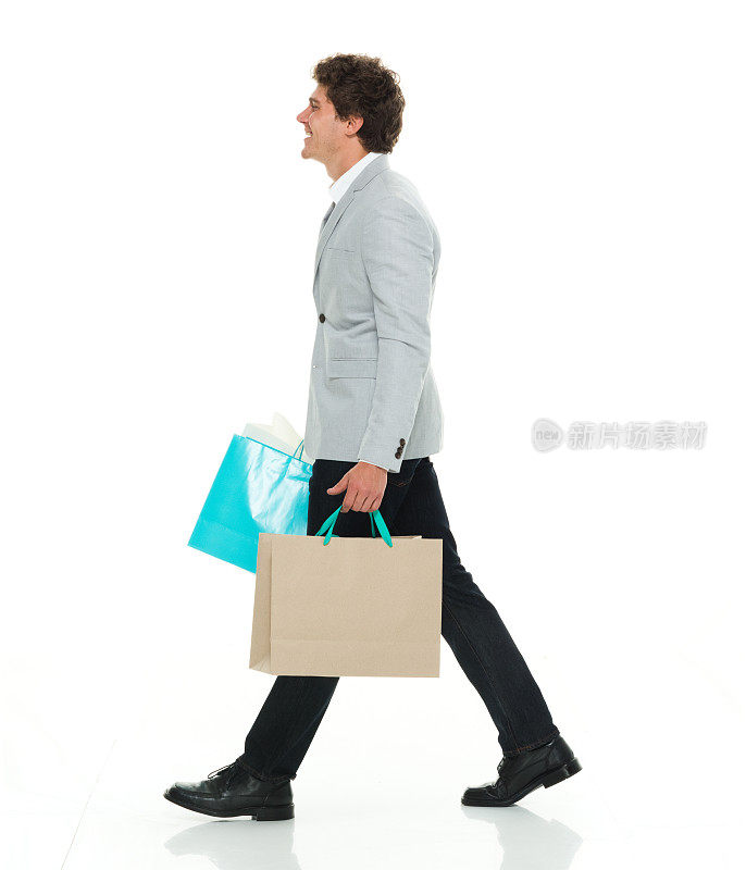 快乐潇洒随意的男人走在购物袋