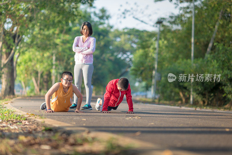 亚洲家庭在公园户外练习瑜伽