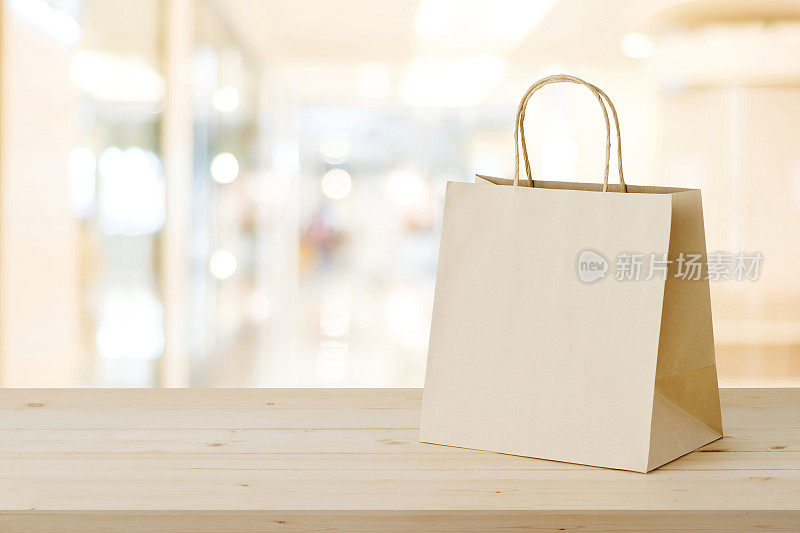 牛皮纸购物袋木桌子上模糊的商店背景，业务，模板，零售，销售