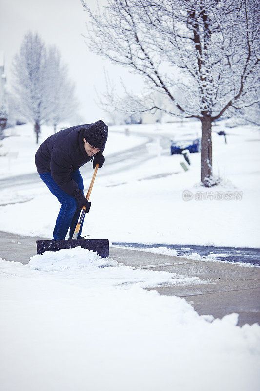 男子努力铲湿雪