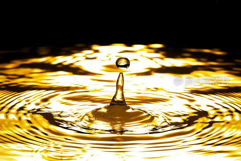 液体黄金滴和波纹，抽象的背景