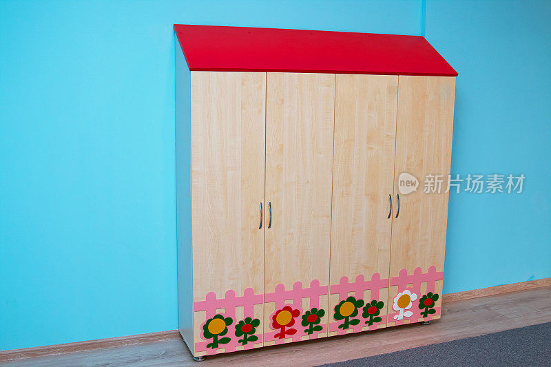 幼儿园的婴儿衣柜。幼儿园或儿童房的彩色木制家具。