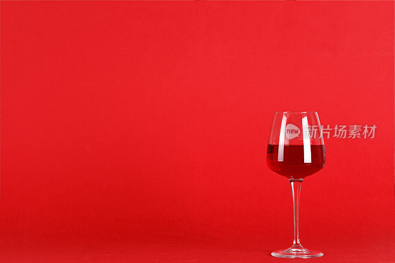 红色背景下的满杯葡萄酒