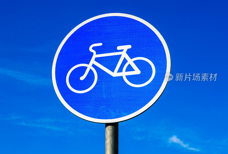 蓝色的天空映衬着自行车道的路标