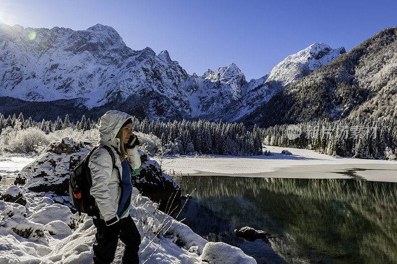 一个年轻的女人在拍摄冬天的清晨田园风光，意大利朱利安阿尔卑斯-拉吉迪富辛，欧洲阿尔卑斯，欧洲
