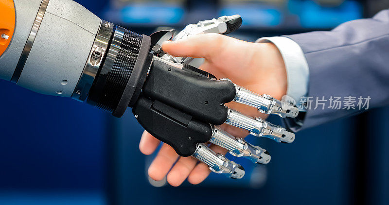 一个商人和一个机器人握手的手。人类与人工智能互动的概念。