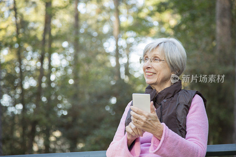 活跃的成年女性在户外使用手机。