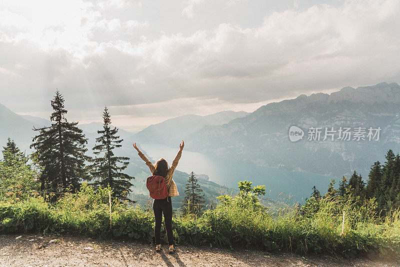 风景的女人看湖在瑞士阿尔卑斯山日落