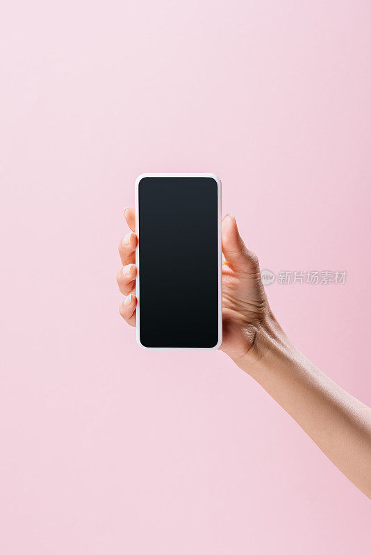 一名女子手持智能手机，空白屏幕被隔离在粉红色的屏幕上
