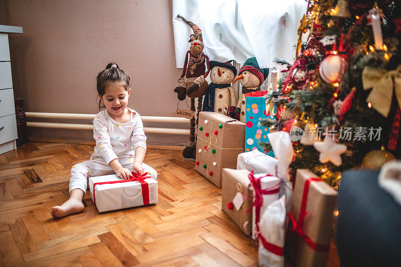 漂亮的小孩在早上打开圣诞礼物