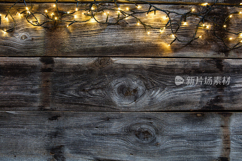 冬季装饰灯在古老的乡村木材上，平铺