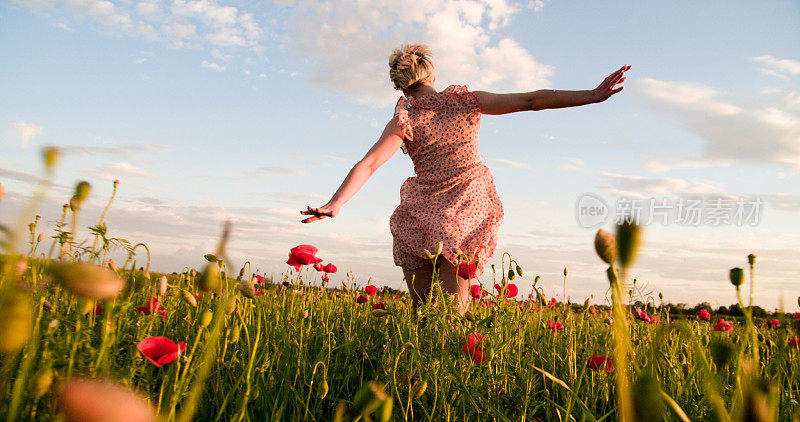 在罂粟花草地上奔跑的女人