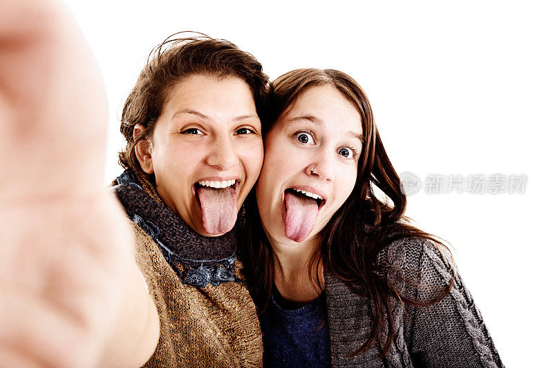 两个可爱的年轻女人傻傻的自拍，吐着舌头