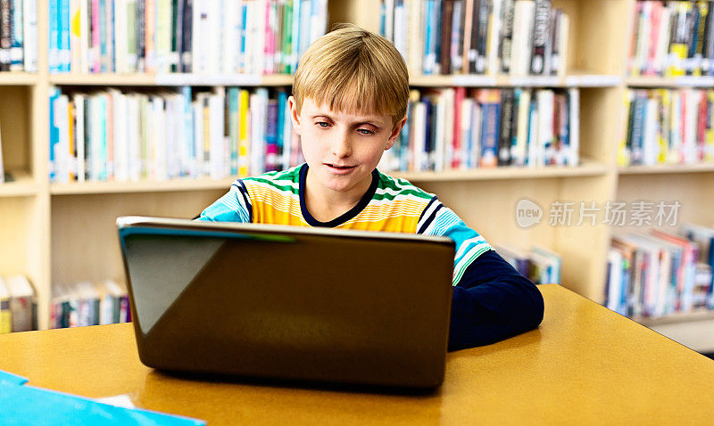 在线和联系;自信的学生在图书馆用笔记本电脑