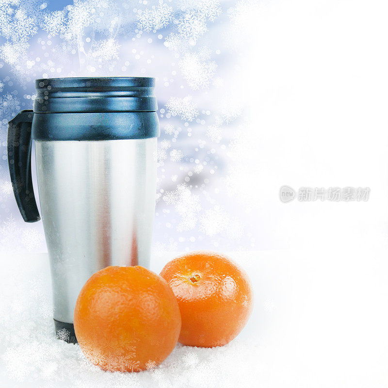 热水瓶旅行杯和橘子在冬天的背景。