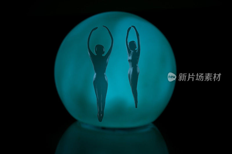 抽象的芭蕾舞人物在一个蓝色玻璃球-黑色的背景