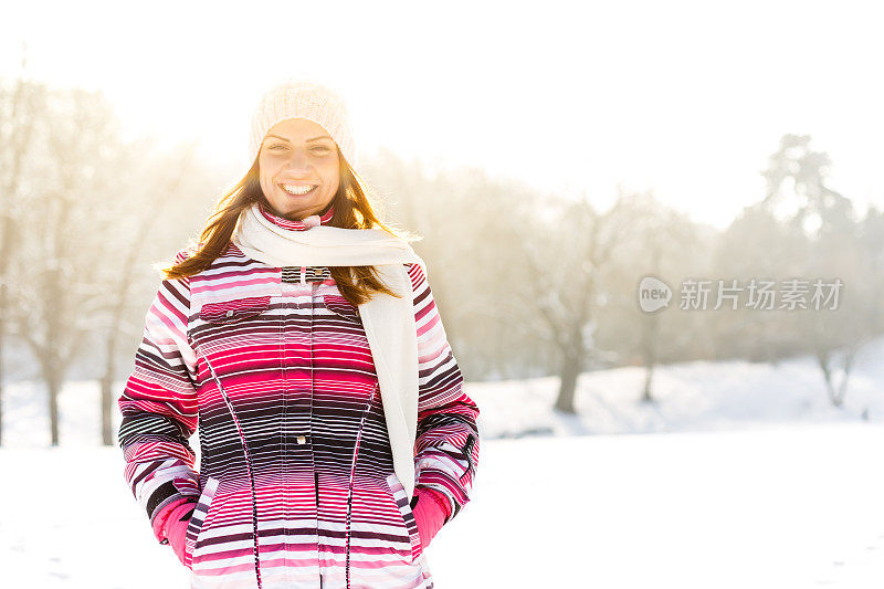 在雪地里戴着围巾和帽子的女人