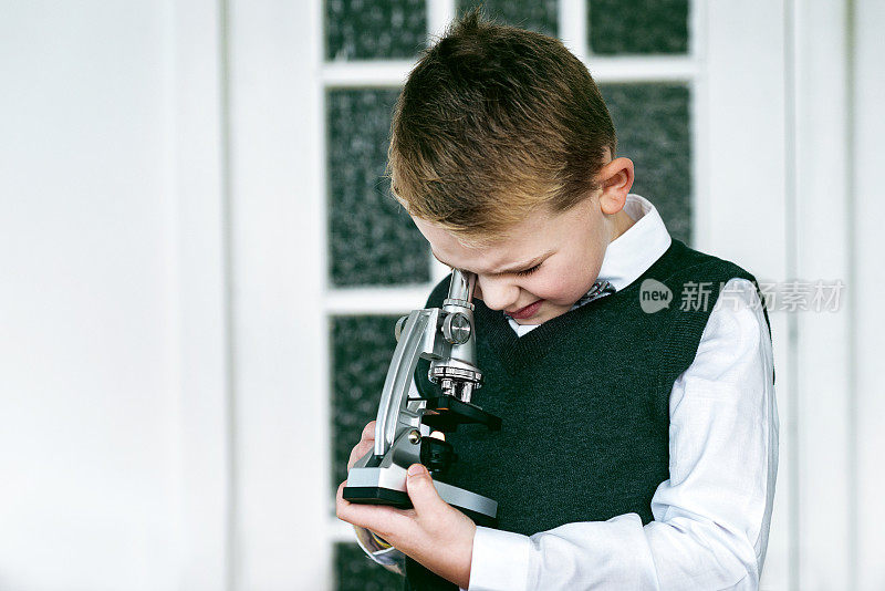 一个男孩用显微镜检查一个物体