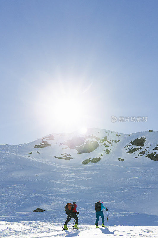 一对高山滑雪夫妇登上山顶