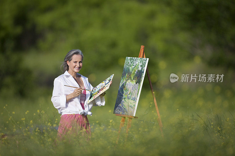 在画布上画着野花野地里的女人