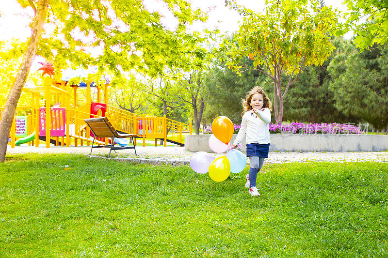 快乐的小女孩玩彩色的气球
