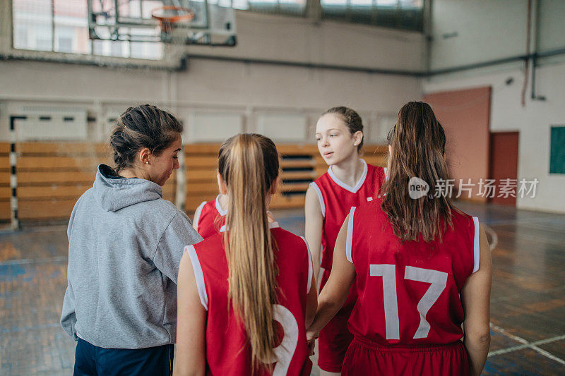 女孩们在听她们的篮球教练训练