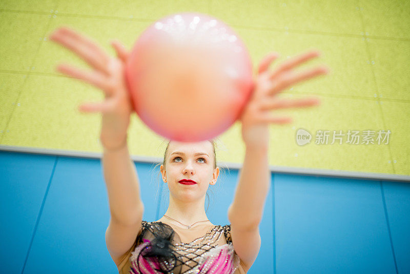 少女女子体操运动员用球表演常规动作的肖像