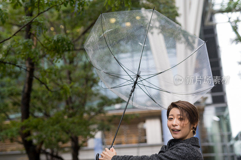 亚洲女人在雨和强风