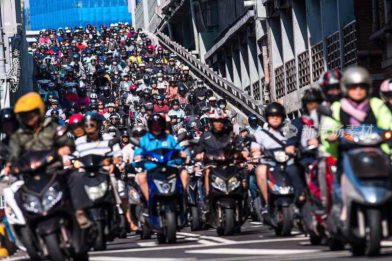 早晨高峰时段，台北市大桥上摩托车飞驰而下。
