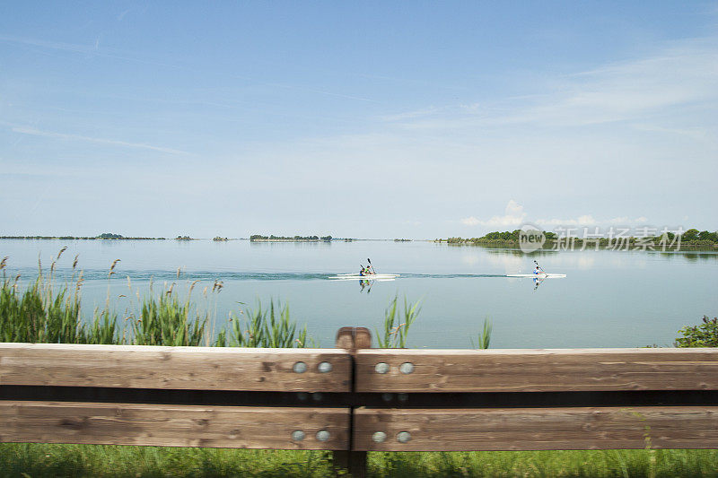 在意大利格拉多湖平静的水中划独木舟的人