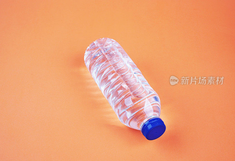 水在塑料瓶孤立的橙色背景