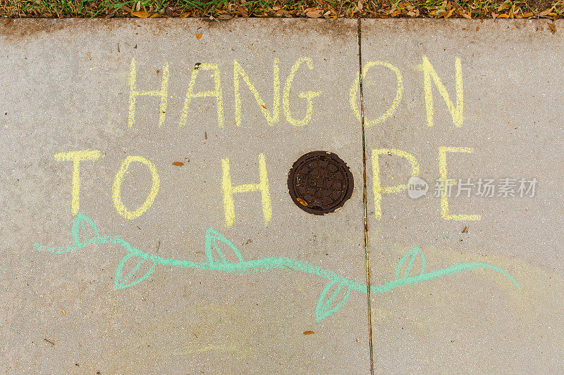 “坚持希望”鼓舞人心的人行道粉笔画