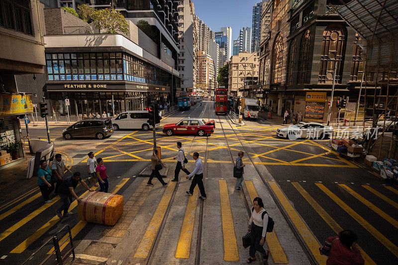 香港的十字路口。行人穿过有轨电车轨道的道路。