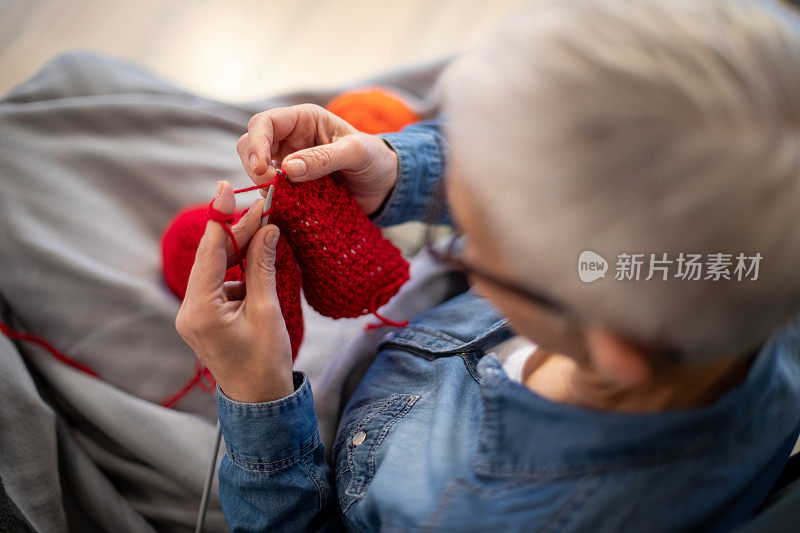 近距离拍摄的成熟女人的手编织在家里。