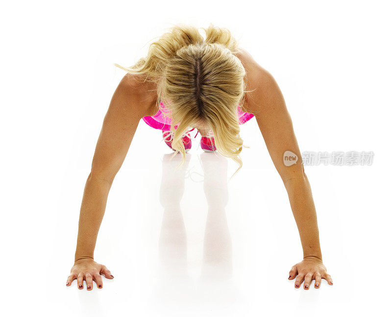 白种人女运动员在白色背景前，穿着胸罩，积极运动训练俯卧撑